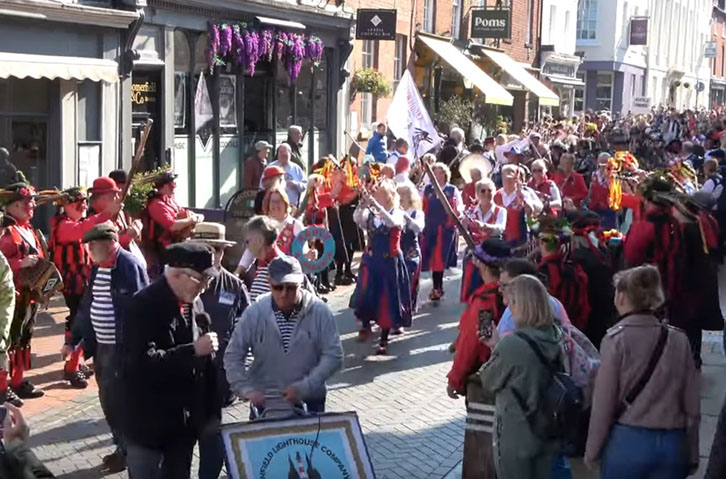 a very crowded street as the teams line up at the end of the parade